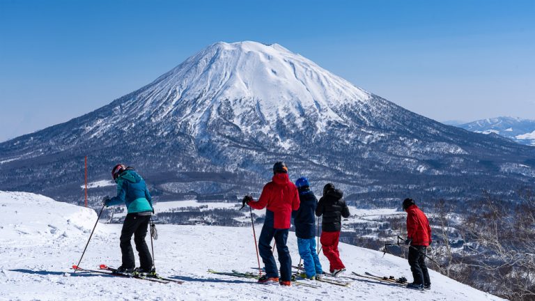 Group skiing on snowy mountain in Japan